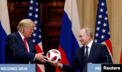 El presidente de EE. UU., Donald Trump, recibe una pelota de fútbol del presidente ruso, Vladimir Putin, mientras celebran una conferencia de prensa conjunta después de su reunión en Helsinki, Finlandia el 16 de julio de 2018. REUTERS / Grigory Dukor.