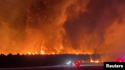 Smoke and flames from bushfire are seen in Gingin, Western Australia in this undated handout image. (Nikki Woods/Dept. of Fire and Emergency Services via REUTERS)
