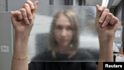 Product design graduate Lucy Hughes holds up a sheet of MarinaTex - an edible and compostable plastic alternative made from byproducts of the fishing industry and other natural ingredients which has won the James Dyson Award, in Brighton, Britain, October