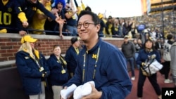 資料照片：在密歇根州安娜堡，在全國大學體育協會(NCAA)大學美式足球賽季密西根對俄勒岡的一次比賽期間，密歇根大學校長小野三太準備向觀賽人群拋擲T恤。(2024年11月2日)