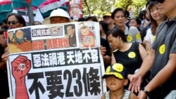 香港民眾舉著反對“惡法”的標語準備參加反對23條立法的大遊行。(2003年7月1日)