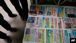 Des journaux ivoiriens étalés à même le sol, à Abidjan, Côte d'Ivoire, le 30 novembre 2010.