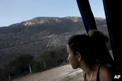 A Central American migrant looks out toward the border with the U.S., between Mexicali and Tijuana, as she rides by bus with a caravan of migrants to Tijuana, Mexico, April 26, 2018.