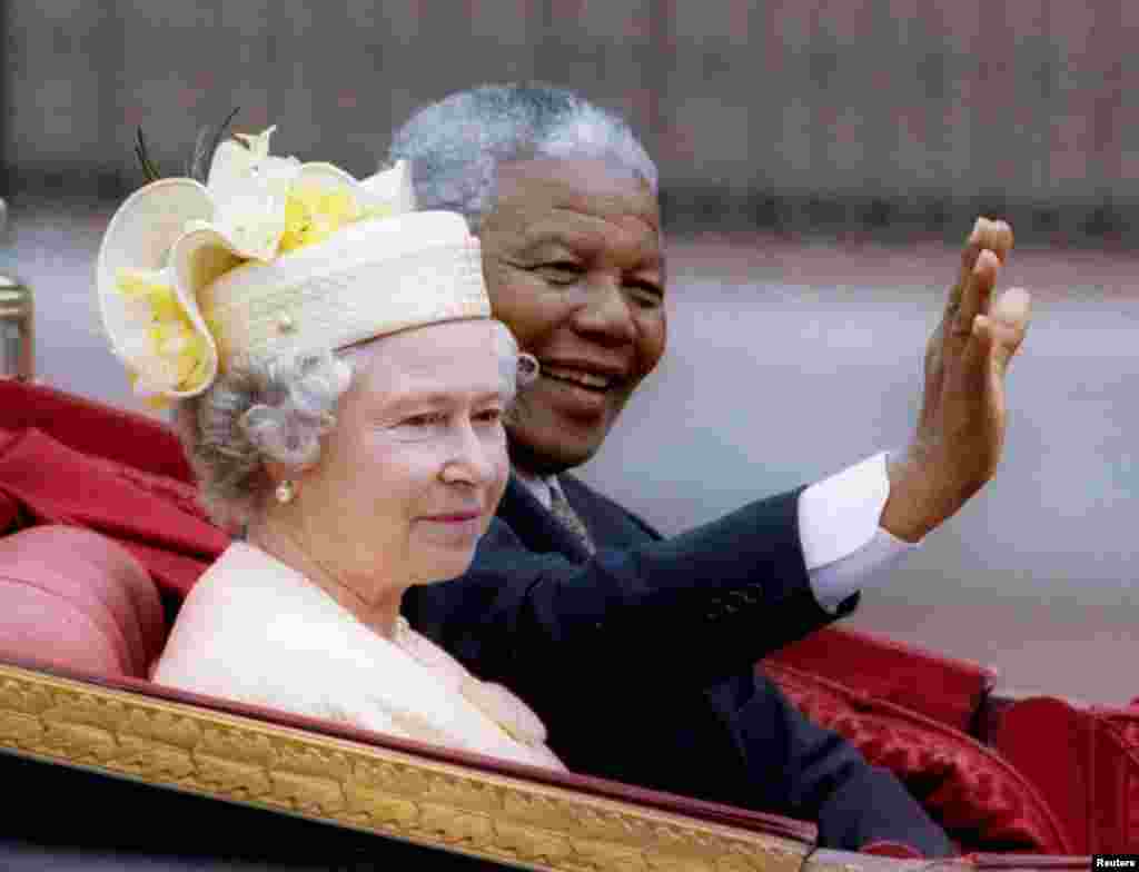 Nelson Mandela et la reine Elizabeth II font un tour en charrette à l'extérieur de Buckingham Palace le premier jour d'une visite d'Etat en Grande-Bretagne, le 9 Juillet, 1996. 