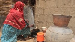 Une femme cuisine au camp informel de Yawuri à la périphérie de Maiduguri, capitale de l'État de Borno, le 29 mars 2021.