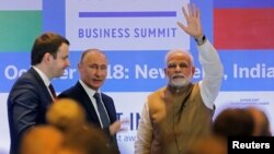 FILE - India's Prime Minister Narendra Modi waves as Russian President Vladimir Putin looks on after attending the India-Russia Business Summit in New Delhi, India, Oct. 5, 2018. 