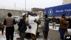 Foto de archivo un trabajador lleva un saco de harina en un centro de distribución del Programa Mundial de Alimentos en Kabul, Afganistán.
