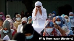 An Indonesian Muslim reacts during mass prayer session at the Great Mosque of Al Azhar during Eid al-Fitr, marking the end of the holy fasting month of Ramadan, amid the coronavirus disease (COVID-19) pandemic in Jakarta, Indonesia, May 13, 2021