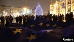 Ljudi dežve veliku zastavu Evropske unije tokom protesta protiv predloga novog zakona o rad, ispred zgrade mađarskog parlamenta, u Budimpešti, 18. decembra 2018.