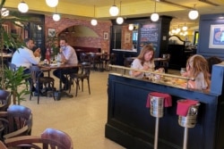 Para pengunjung restoran duduk menikmati hidangannya, setelah pemerintah untuk pertama kalinya mengizinkan restoran beroperasi secara bebas selama jam puasa Ramadan di Dubai, Uni Emirat Arab, 2 Mei 2021. (REUTERS / Abdel Hadi Ramahi)