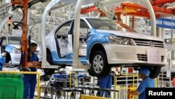 資料照：中國新疆烏魯木齊市德國大眾汽車公司上汽大眾工廠的工人正在組裝汽車。（2018 年9月4日）