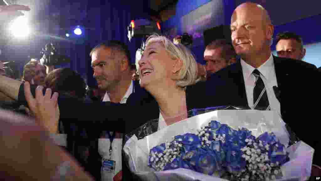 'Yar takara mai ra'ayin mazan jiya Marine Le Pen tana gewaye da masu tsaronta yayin da take gaida nagoya bayanta, ranar Lahadi 23 ga watan Afrilu na spekar 2017. &nbsp;