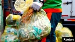 Seorang pekerja membawa kantong sampah medis di Jakarta. (dok: REUTERS/Ajeng Dinar Ulfiana)