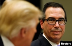 US Treasury Secretary Steve Mnuchin (R) listens to US President Donald Trump speak during a 'strategic initiatives"'lunch at the White House in Washington, Feb. 22, 2017