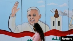 Une peinture murale du pape François est visible sur le mur d'une église lors de sa prochaine visite en Irak, à Bagdad, en Irak, le 22 février 2021.