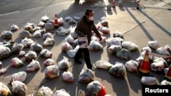 中國陝西西安新冠防疫封城後一名工作人員為居家隔離的小區居民準備食品供應。 （2021年12月23日）