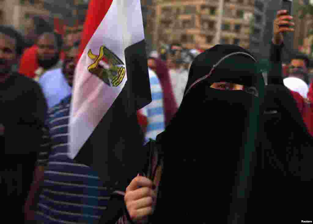 Prezident Muhammad Mursiyning tarafdorlari davlat bayrog'ini ko'tarib, namoyishga otlanmoqda, Tahrir maydoni, Qohira, Misr, 10-iyul, 2012-yil.