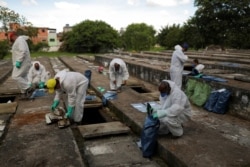 Sepultureros en Sao Paulo, Brasil, exhuman huesos de viejas tumbas para hacer espacio para víctimas de COVID-19, el 1 de abril de 2021.