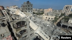 17 Temmuz 2024 - Abdullah Azzam Camii'nin minaresi, Gazze Şeridi'nin orta kesimindeki Nuseyrat mülteci kampında, İsrail-Hamas çatışması sırasında bir İsrail saldırısı sonucu caminin vurulmasının ardından bir evin üzerine yıkıldı.