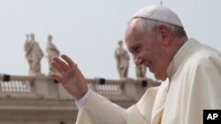 FILE - Pope Francis waves after his weekly general audience in St. Peter's Square at the Vatican, Sept. 9, 2015.