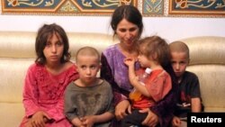 A woman and her children are seen after being freed from the Islamic State in Sweida, Syria, Oct. 20, 2018. 
