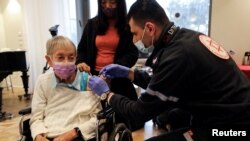 FILE - Lili Zohari, 90, receives a fourth dose of the COVID-19 vaccine in a retirement home in Netanya, Israel, Jan. 5, 2022.