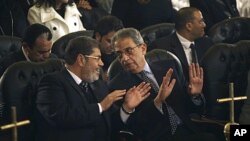 "Musulmon Birodarlar" partiyasidan prezidentlik uchun yangi nomzod Muhammad Mursiy (chapda) hamda prezidentlikka yana bir nomzod, Misr sobiq Tashqi ishlar vaziri Amr Musa Qohiradagi nasorolar cherkovida. 6-yanvar, 2012-yil.