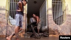 Un afectado por las inundaciones en Cumanacoa, en el estado oriental de Sucre, saca barro de su vivienda, el 2 de julio de 2024.