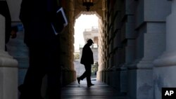 សមាជិក​ព្រឹទ្ធសភា​សហរដ្ឋ​អាមេរិក​ម្នាក់ មក​ដល់​វិមាន​សភា​សហរដ្ឋ​អាមេរិក​ក្នុង​រដ្ឋធានី​វ៉ាស៊ីនតោន​កាលពី​ថ្ងៃទី២៩ ខែកញ្ញា ឆ្នាំ២០២១ សម្រាប់​ការបោះឆ្នោត​អំពី​វិធានការ​ថវិកា​ដើម្បី​បញ្ចៀស​ការបិទ​ផ្នែក​ខ្លះ​នៃ​រដ្ឋាភិបាល​សហព័ន្ធ។