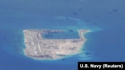 FILE - Chinese dredging vessels are purportedly seen around Fiery Cross Reef in the disputed Spratly Islands in the South China Sea in this image from video taken by a P-8A Poseidon surveillance aircraft provided by the U.S. Navy, May 21, 2015. 