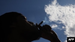 Muškarac puši marihuanu na neformalnoj proslavi kanabisa u Vašington skver parku u Njujorku, 20. aprila 2024.