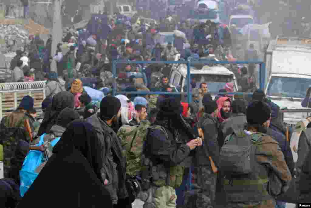 Rebel fighters and civilians gather as they wait to be evacuated from a rebel-held sector of eastern Aleppo, Syria, Dec. 16, 2016.