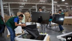 FILE - Workers check screens at an LG flat screen TV assembly plant in Reynosa, Mexico, across from McAllen, Texas, March 23, 2017. On Jan. 5, 2019, it was announced that Mexican business and labor leaders had agreed to double the minimum wage along the border.
