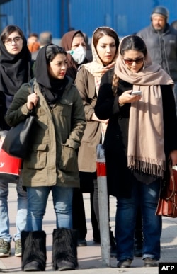 FILE - Iranian women wearing hijabs walk down a street in the capital, Tehran, Feb. 7, 2018.