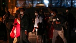 People wearing face masks as a precaution against the coronavirus wait for a bus in Hyderabad, India, Jan. 9, 2022.
