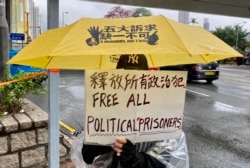声援47名香港民主派人士的市民手持标语 （美国之音/汤惠芸）