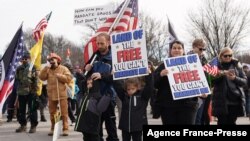 واشنگٹن ڈی سی میں کرونا سے بچاؤ کے سلسلے میں عائد ویکسین لگوانے اور ماسک پہننے سمیت دیگر پابندیوں کے خلاف مظاہرہ۔