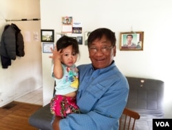 Chhiv Chhy, 63, a client of the mental health community organization CERI that helps former refugees in San Francisco Bay area holds his granddaughter after an interview with VOA Khmer at his home in Oakland, August 31, 2016.
