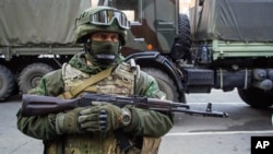 FILE - A pro-Russia rebel stands guard during preparations for a prisoner exchange in Donetsk, eastern Ukraine, Oct. 29, 2015.