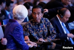 Christine Lagarde, direktur pelaksana Dana Moneter Internasional (IMF), kiri, berbincang dengan Presiden Joko Widodo pada pembukaan pertemuan tahunan Dana Moneter Internasional – Bank Dunia 2018 di Nusa Dua, Bali, 12 Oktober 2018