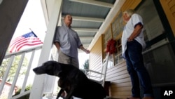 FILE - Virginia voter Harry Donahue talking to his wife Nancy on the front porch of their farmhouse, built in the 1700's, in Farmville, Va.