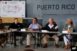 President Donald Trump and first lady Melania Trump participate in a briefing on hurricane recovery efforts with first responders at Luis Muniz Air National Guard Base, Tuesday, Oct. 3, 2017, in San Juan, Puerto Rico