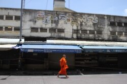 ព្រះសង្ឃមួយអង្គកំពុងនិមន្តកាត់ខាងមុខផ្សារចាស់ ដែលកំពុងត្រូវបិទដំណើរការលក់ដូរ ក្រោយរដ្ឋាភិបាលប្រកាសបិទផ្សារមិនរៀបរយទូទាំងរាជធានី ដើម្បីទប់ស្កាត់ការរីករាលដាលជំងឺកូវីដ១៩ ក្នុងអំឡុងពេលបិទខ្ទប់នៅរាជធានីភ្នំពេញ និងក្រុងតាខ្មៅ ថ្ងៃទី២៦ ខែមេសា ឆ្នាំ២០២១។ (កាន់ វិច្ឆិកា/វីអូអេ)