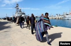 FILE - Migrants arrive at a naval base after they were rescued by the Libyan coast guard in Tripoli, Libya, March 13, 2018.