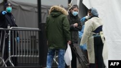 Ljudi čekaju da se testiraju na koronavirus ispred bolnice u Kvinsu, u Njujorku