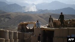 Uzoqdan AQSh havo hujumlarini kuzatayotgan afg'onlar, Nangarhor viloyati, 7-iyul, 2018