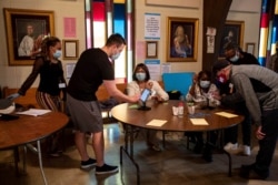 Personas firman su nombre antes de votar en la Iglesia Metodista Unida Lawrenceville Road, en Tucker, Georgia, durante la elección complementaria para el Senado, el martes 5 de enero de 2021.