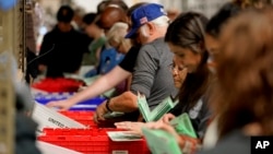 Фото: працівники виборчої дільниці звіряють підписи на бюлетенях, 8 листопада, Фіникс, Арізона