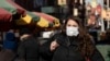 A woman who declined to give her name wears a mask, Jan. 30, 2020, in New York. She works for a pharmaceutical company and said she was concerned about coronavirus infection. "I'd wear a mask if I were you," she said. 