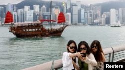 遊客在香港尖沙咀的維多利亞灣前拍照留影。 （2024年4月29日）